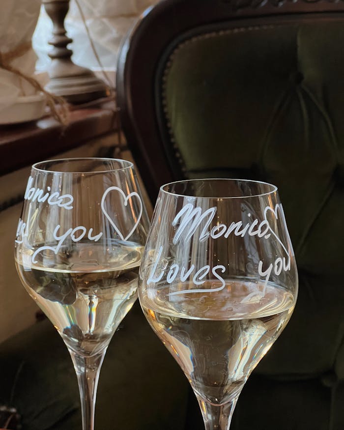 Close-up of two wine glasses with romantic engravings, perfect for celebrations.